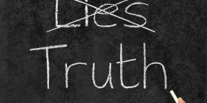 Crossing out Lies and writing Truth on a blackboard.